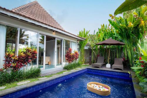 a swimming pool in front of a villa at Tanta Escape in Tegalalang