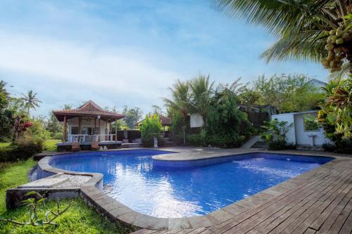 a swimming pool in a backyard with a gazebo at Tanta Escape in Tegalalang