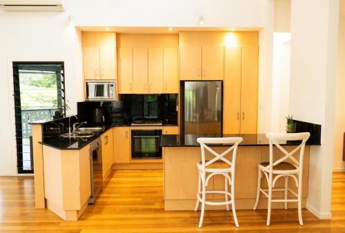 una cocina con armarios amarillos y 2 taburetes en Oceanside Escape, Heated Pool, Fire Pit and 4 Beds, en New Brighton