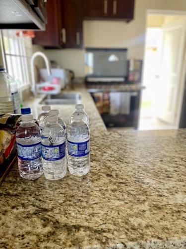 a group of water bottles sitting on a kitchen counter at Resort Vibes Getaway - Colbeck Manor Old Harbour - Gated, pool, gym in Old Harbour