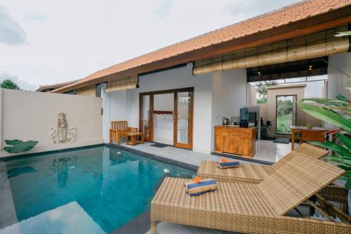 a villa with a swimming pool and a house at Uma Jala Villa Ubud in Ubud