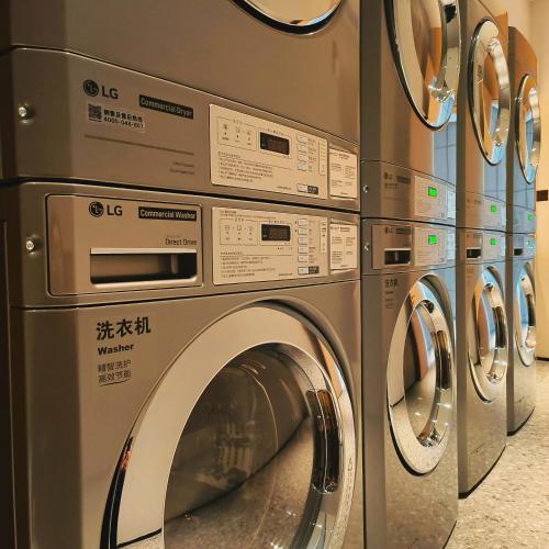 a row of washing machines in a laundry room at Wanda Jin Xiaohe Xincheng in Taiyuan