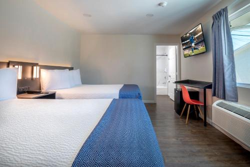 a hotel room with two beds and a desk at La Casita Inn in Wilmington