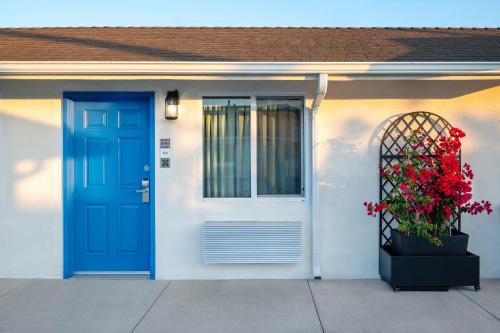 a house with a blue door and a plant with red flowers at La Casita Inn in Wilmington