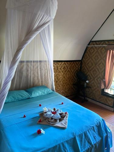 a bedroom with a blue bed with flowers on it at BARENG -BARENG gili bungalows in Gili Meno