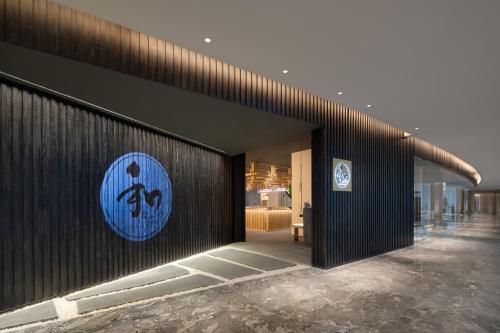 a building with a blue sign on the side of it at Wanda Jin Xiaohe Xincheng in Taiyuan