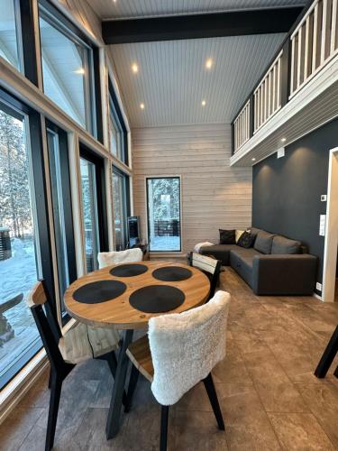 a living room with a wooden table and chairs at Norvamaja with a lake view, sauna and jacuzzi in Rovaniemi