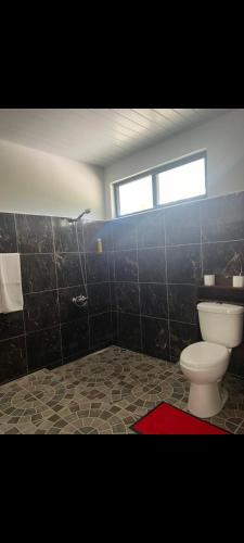 a bathroom with a toilet and a window at Fare Kahaia Rangiroa in Avatoru