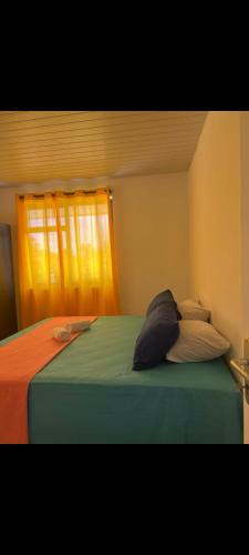 a bed with two pillows in a bedroom with a window at Fare Kahaia Rangiroa in Avatoru