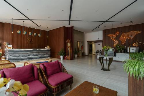 a lobby with purple chairs and a table and a counter at Celine Express - Q Dalat Hotel in Da Lat