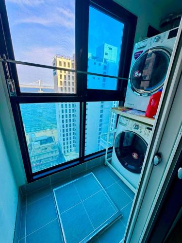 a washing machine in a room with a window at Casa Felice in Busan