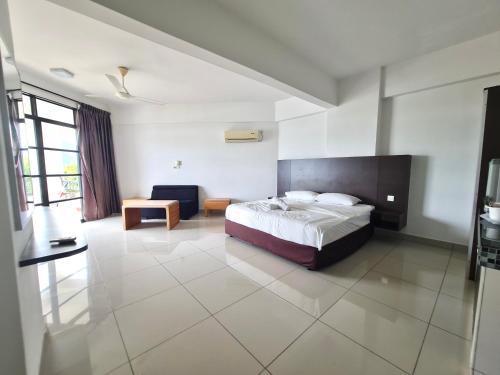 ルムットにあるMarina Teluk Batik by Manhattan Groupのベッドルーム1室(ベッド1台付)、ソファ付きのベッドルーム1室が備わります。