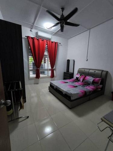 a bedroom with a bed and a ceiling fan at Ahmad Albab Homestay in Pekan