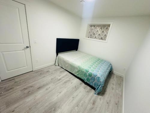 カルガリーにある2 bedroom Basement Suiteの隅にベッドが置かれた小さな寝室