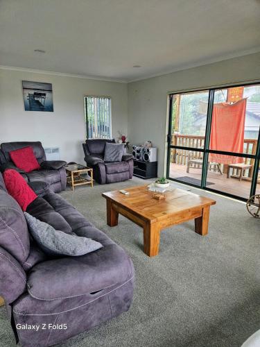 a living room with a couch and a coffee table at Welcomebay Haven in Tauranga
