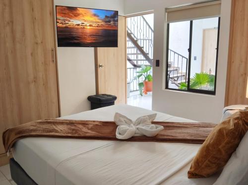 a bedroom with a bed with a bow on it at Casa Hotel La Bonita in Medellín