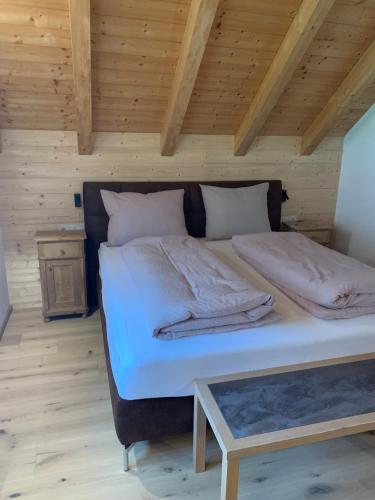 a large bed in a room with a wooden ceiling at Apartments Antersi Maria in San Vigilio Di Marebbe