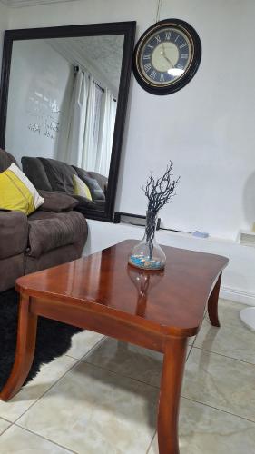 a living room with a coffee table and a clock at Tranquility Hideaway in Mandeville
