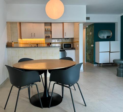 a kitchen with a wooden table and chairs at Apartamentos Boutique Poniente Playa in San Antonio