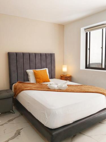 a bedroom with a large bed and a window at Casa Hotel La Bonita in Medellín