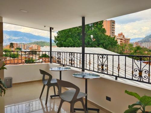 a balcony with two tables and chairs and a view at Casa Hotel La Bonita in Medellín
