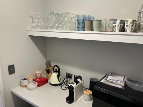 a kitchen counter with a counter top with glasses on a shelf at Myalup Retreat in Binningup