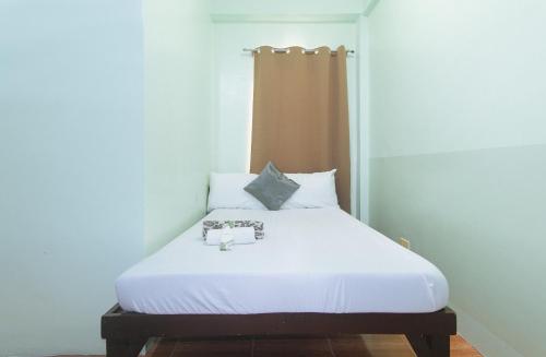 a bed in a room with white sheets and pillows at En Gedi Beach Resort by RedDoorz in Iba