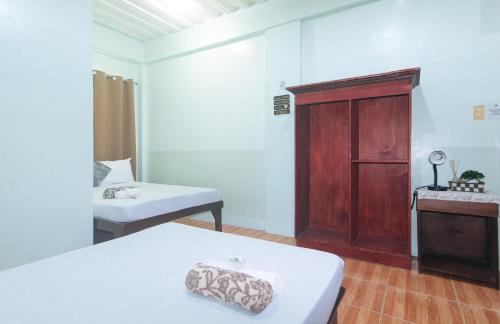 a room with two beds and a wooden cabinet at En Gedi Beach Resort by RedDoorz in Iba