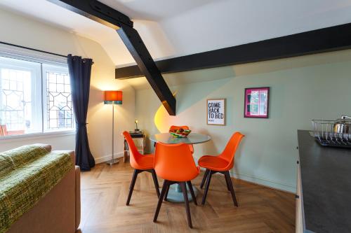 a dining room with a table and orange chairs at Chester Apartment with Nice Outdoor Views in Chester