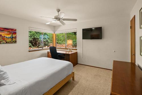a bedroom with a bed and a desk and a window at Mountain Shadows Escape with a Yoga Studio! in Sedona