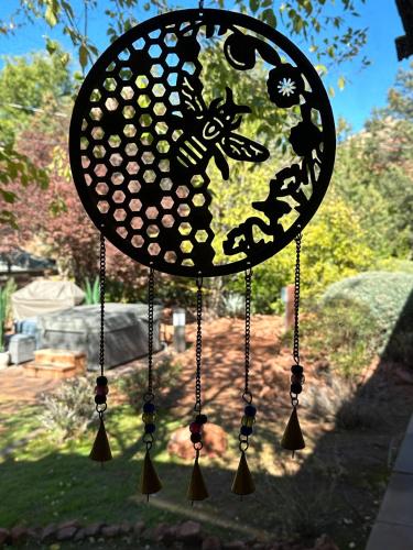 a clock with a bee on it hanging in a yard at Mountain Shadows Escape with a Yoga Studio! in Sedona