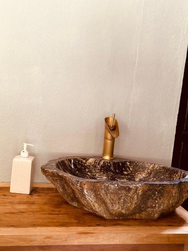 a bathroom sink with a gold faucet on a wooden counter at Ananda Home in Tân Hiệp