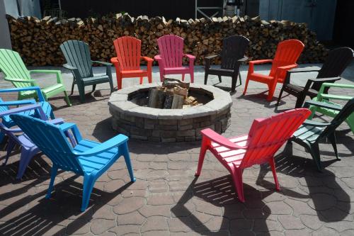 a group of colorful chairs sitting around a fire pit at Lake George Escape in Warrensburg
