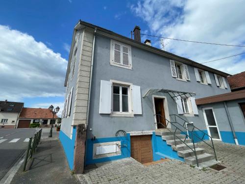 a blue house with blue trim on a street at Cramiland - Appart 01 Ohnenheim in Ohnenheim