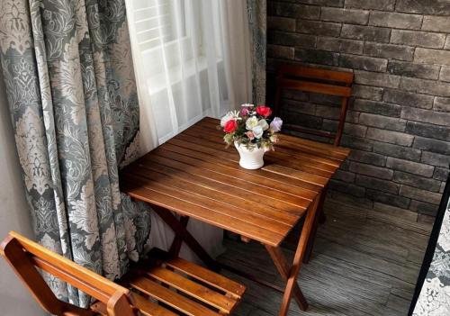 a wooden table with a vase of flowers on it at Marani Boutique in Tbilisi City
