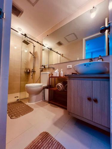 a bathroom with a sink and a toilet and a shower at Bliss and Bryce Crib 1 at Azure North Pampanga in San Fernando