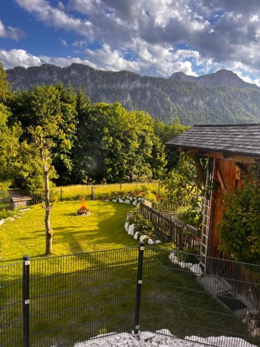 a fence in front of a yard with a mountain at AtterseeSuite in Unterach am Attersee