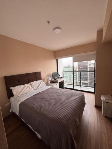 a bedroom with a large bed and a large window at Apartment in San Isidro in Lima