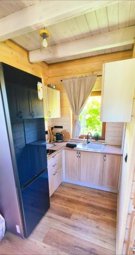 a kitchen with wooden cabinets and a sink at AURA - przytulny drewniany domek na wsi in Krzesimów