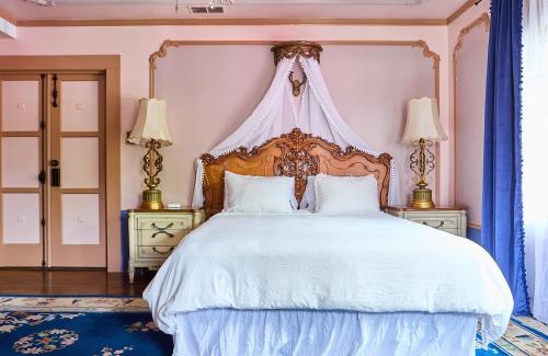 a bedroom with a large white bed with a canopy at Luxurious Hollywood Homestay in Los Angeles