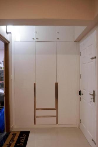 a closet with white cabinets in a room at PLATiNUM AIRPORT LOUNGE in Nedumbassery