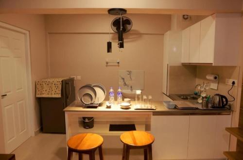 a small kitchen with two chairs and a small table at PLATiNUM AIRPORT LOUNGE in Nedumbassery