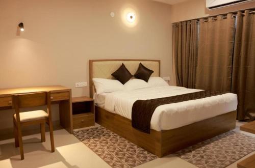 a hotel room with a bed and a desk and a bed sidx sidx sidx sidx at PLATiNUM AIRPORT LOUNGE in Nedumbassery