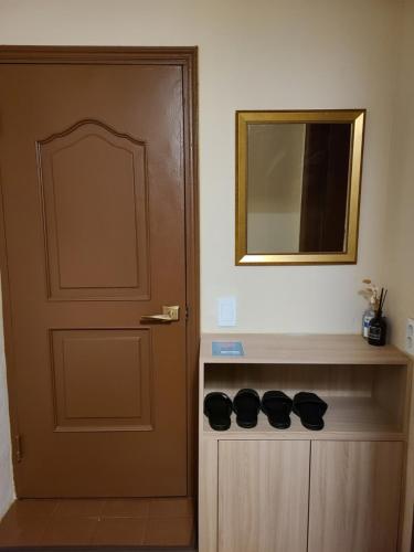 a door with a mirror and a shelf with shoes at Batwo Stay - For foreigners only in Seoul