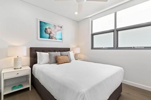 a bedroom with a bed and a window at Azure Apartments Bondi by Urban Rest in Sydney
