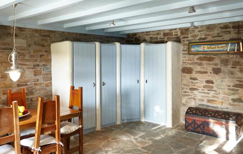 a dining room with blue cabinets and a table at Dinora Villa in Agios Ioannis Tinos