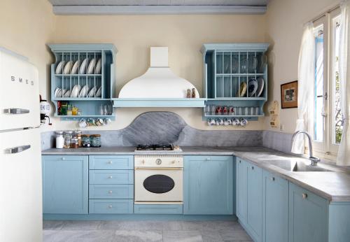 a kitchen with blue cabinets and a sink at Dinora Villa in Agios Ioannis Tinos