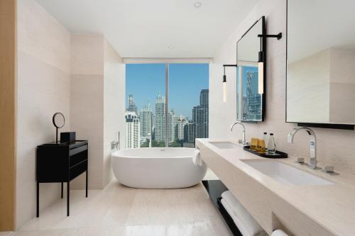 a bathroom with a large tub and a large window at Park Hyatt Bangkok in Bangkok