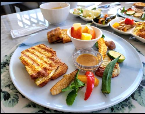 a plate of food with toast and vegetables and dips at Brighthouse in Suao