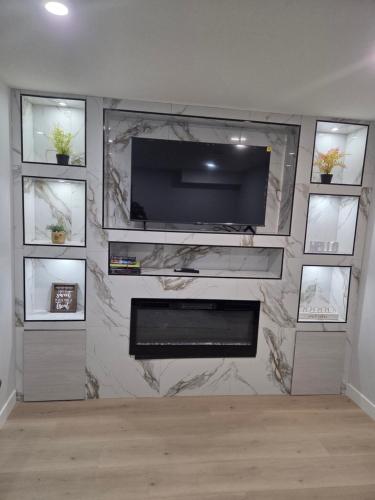 a living room with a television on a wall at Exclusive Suite in Edmonton in Edmonton
